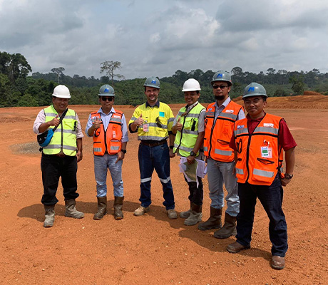 Satisfied employees and customers standing on cleared land