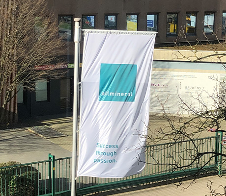 Flagge mit allmineral Firmenlogo weht im Wind